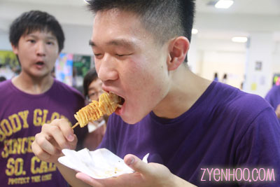 Hon Wye enjoying a Twist Potato while Wei Ter looks on jealously